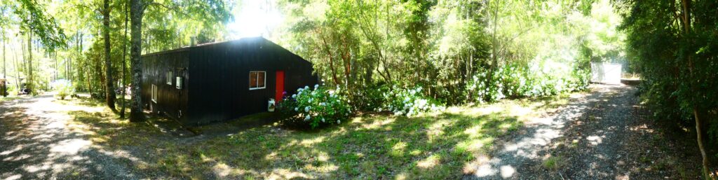 Exterior rodeado de vegetación de la cabaña grande